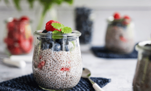chia pudding with berries a sprig of mint in a glass jar