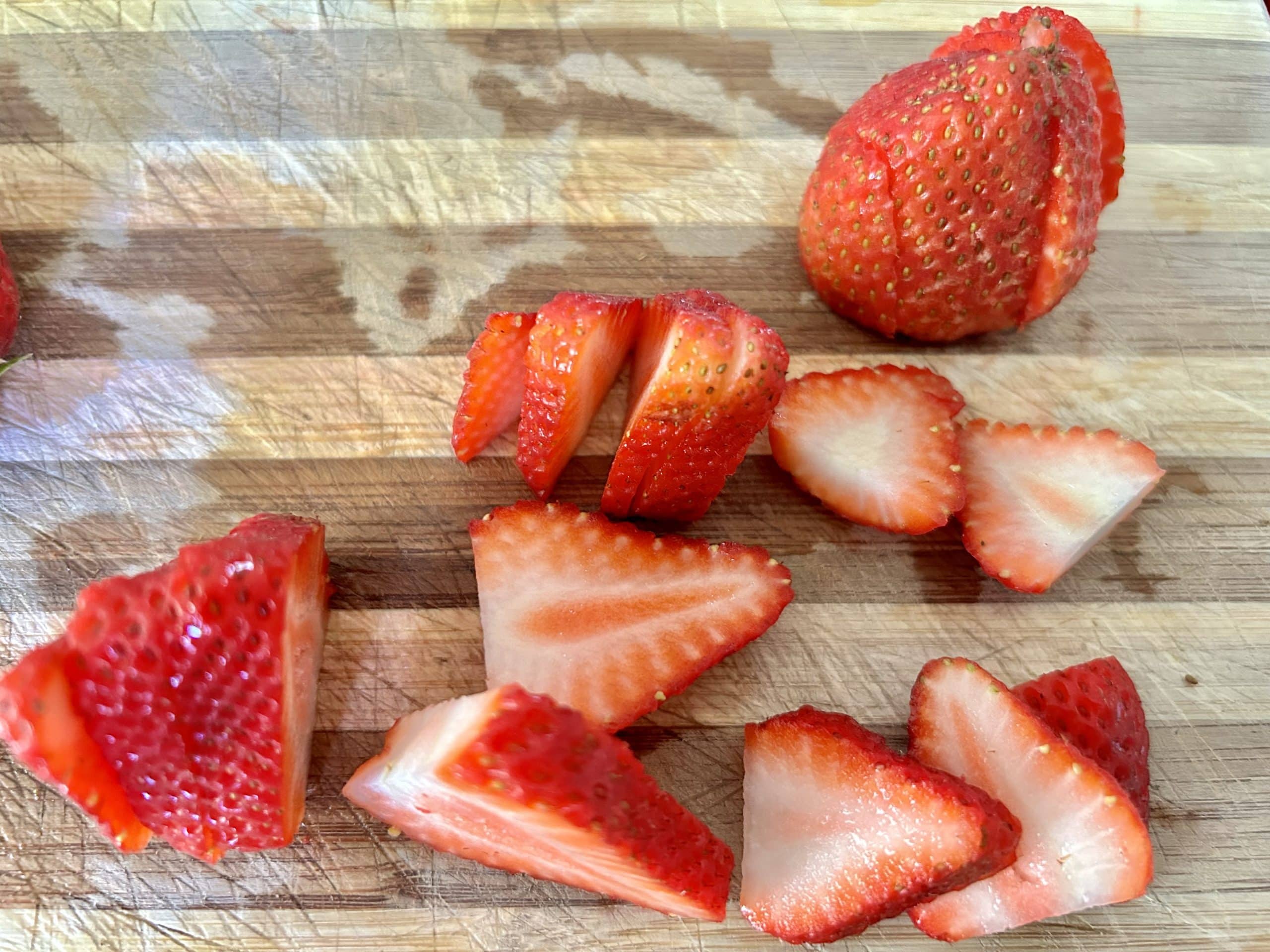 Sliced strawberries on cutting board