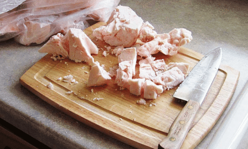 Picture of beef tallow on a cutting board with a knife